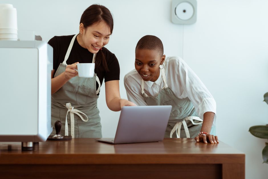 Chủ doanh nghiệp nhỏ đang làm việc với laptop tại quán cà phê