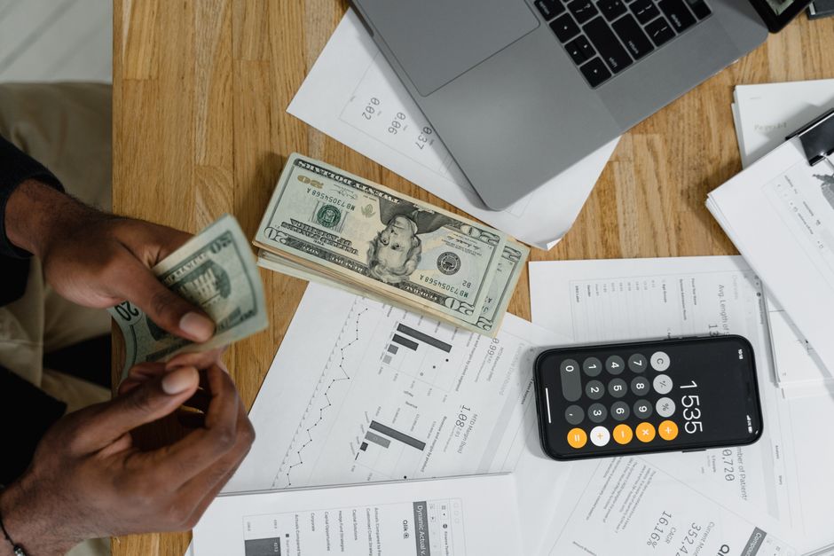 Business owner looking stressed at financial documents and laptop