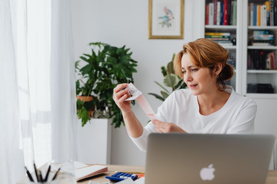 Chủ doanh nghiệp nhỏ đang xem xét bảng chi phí và hiệu quả đầu tư website trên máy tính
